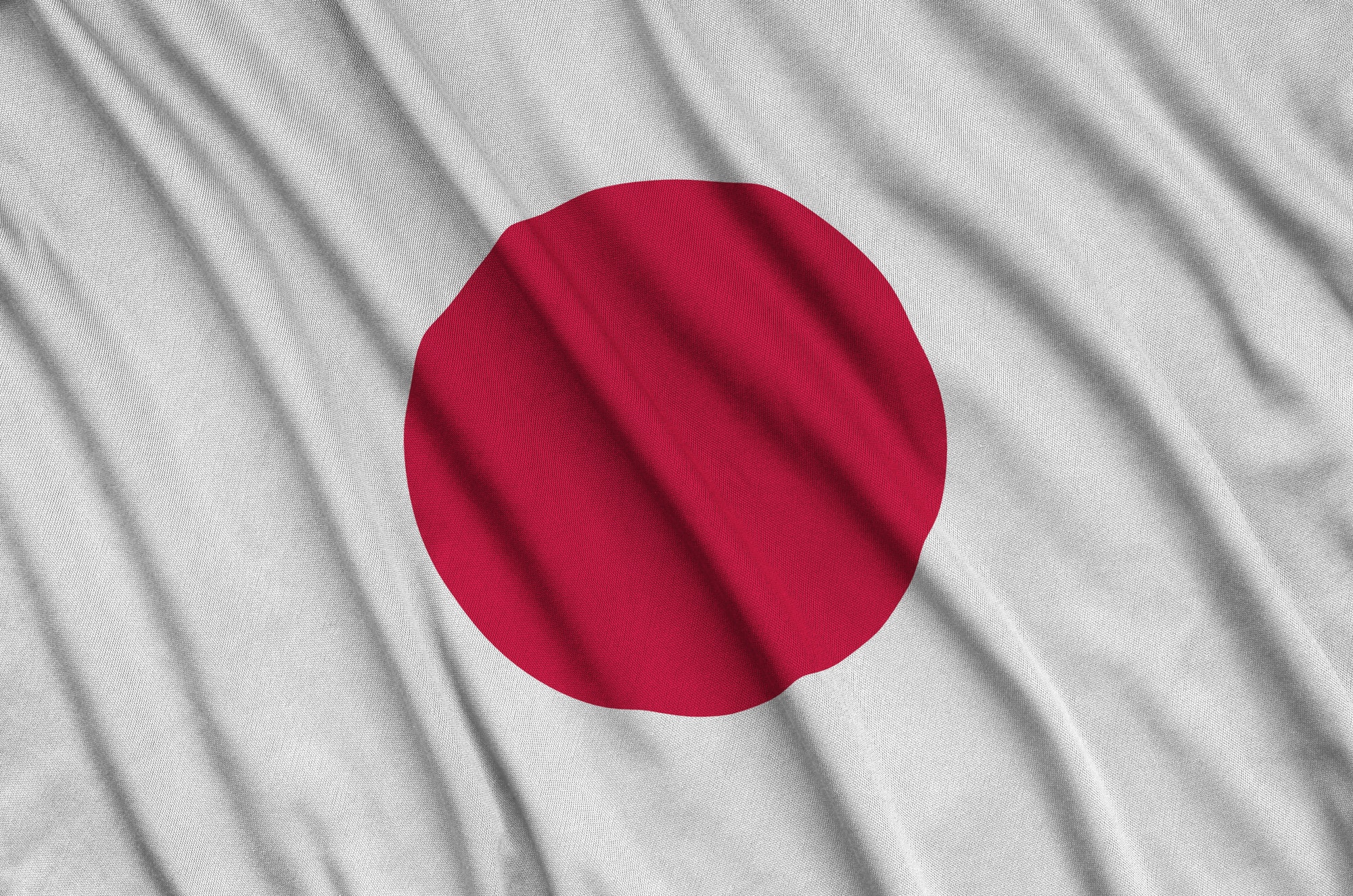 japan-flag-is-depicted-on-a-sports-cloth-fabric-with-many-folds-sport-team-waving-banner.jpg